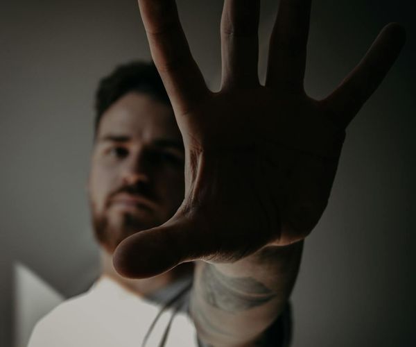 Silhouette of a man in a focused pose against a dawn-colored background.